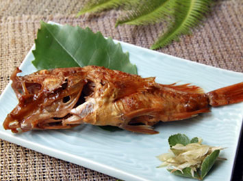 炊き合わせ（ガシラの煮付け）[b]今日は磯物の型の良いガシラがに入りましたので、煮付けにしました。大将の上品な味付けもあり、大きなガシラも『美味しかった』と完食いただきました。ハマボウフの葉とミョウガの花を添えています。