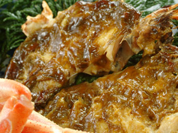 カニ料理「カニの蟹味噌焼き（焼きガニ）」[b]カニの旨味と香りを引き出す焼きガニ。「本陣粋月」では、特にカブ(腹の身）に「純粋な蟹味噌(添加物一切無し)」をふんだんに使い、より香ばしく焼き上げます。